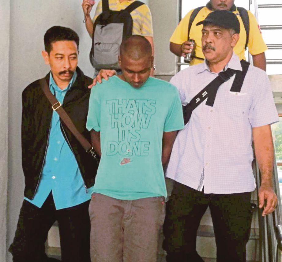 ANGGOTA polis mengiringi  Nadesan (tengah) di pekarangan mahkamah, semalam.