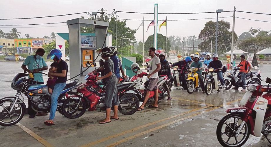 PEMILIK motosikal beratur untuk mengisi minyak secara percuma di Jalan Seremban-Kuala Pilah, semalam.