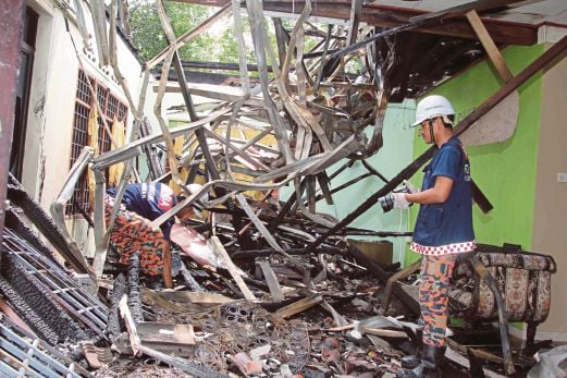PEGAWAI Forensik Jabatan Bomba dan Penyelamat Alor Setar melakukan siasatan di dalam rumah yang terbakar di Kampung Pengkalan Tok Puteh.