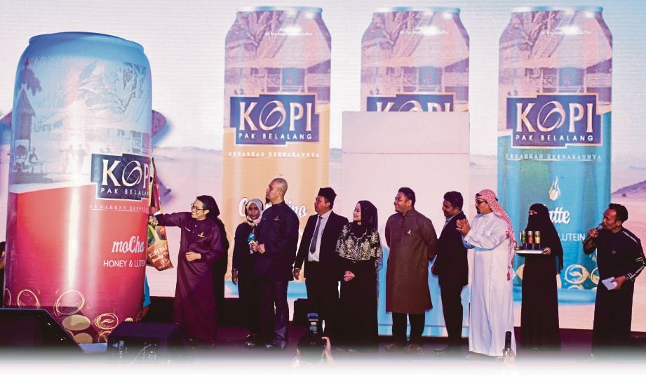 DR Rozaini (kiri) menurunkan tandatangan pada replika tin minuman pada pelancaran produk baharu dan penyampaian Anugerah Usahawan ARBA. 