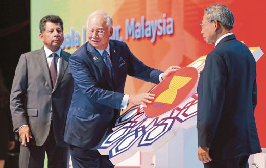 Najib meletakkan logo ASEAN sebagai simbolik perasmian Sidang Kemuncak Perdagangan dan Pelaburan ASEAN 2015 sambil disaksikan Menteri Perdagangan Antarabangsa dan Industri, Datuk Seri Mustapa Mohamed (kanan) dan Mohd Munir.