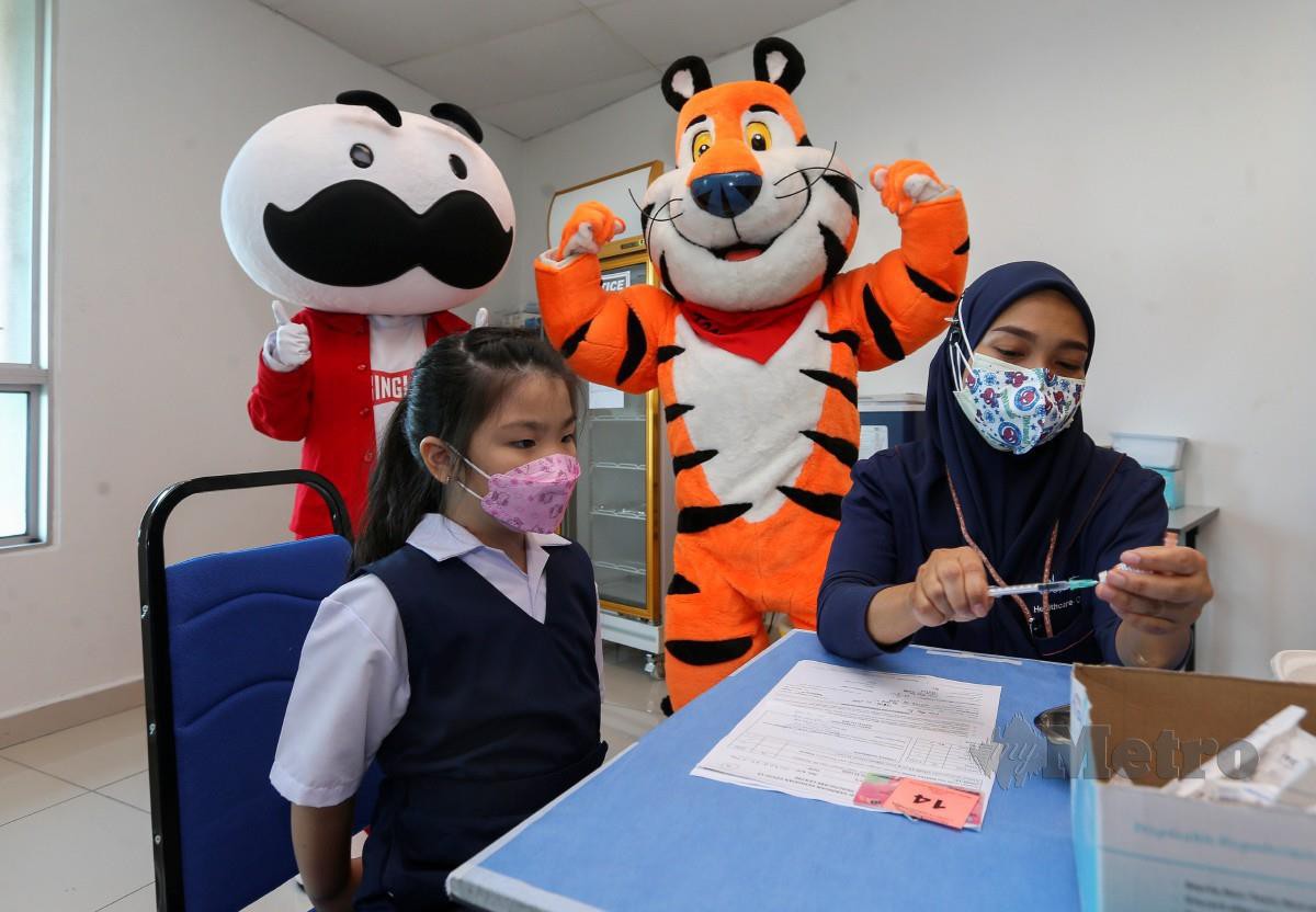 Kanak-kanak menerima vaksin ditemani maskot Mr P dan Tony Tiger pada PICKids di Seremban, Negeri Sembilan. FOTO Azrul Edham Mohd Aminuddin.