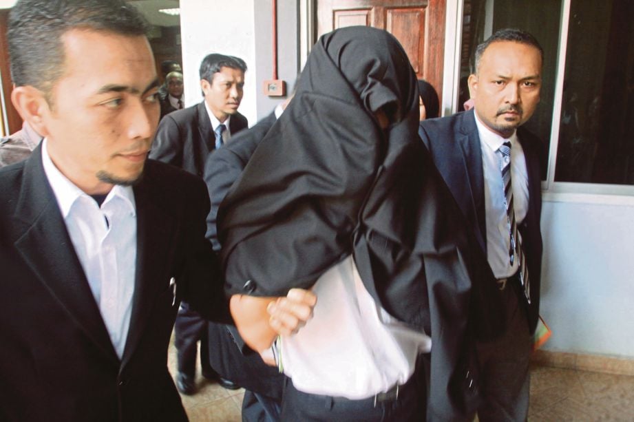 WAN Abd Razak (tengah)  diiringi keluar dari Mahkamah Sesyen Kota Bharu, semalam.