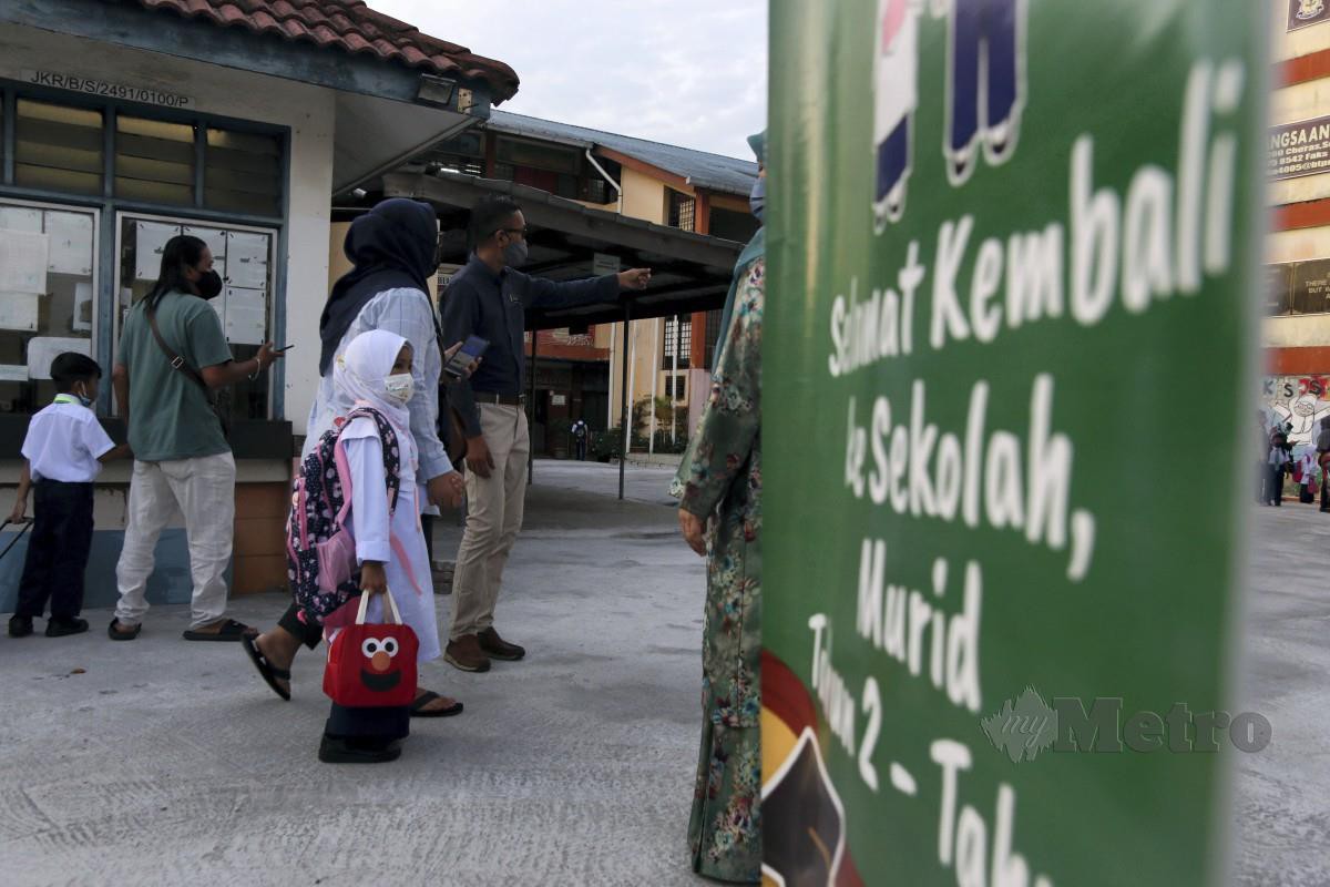 IBU bapa menghantar anak ke Sekolah Kebangsaan Batu Sembilan pada hari pertama sesi persekolahan 2022/2023. FOTO Amirul Johari.