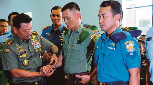 MOELDOKO (kiri) memakaikan jam pada seorang anggota tentera di Bengkulu, semalam. 