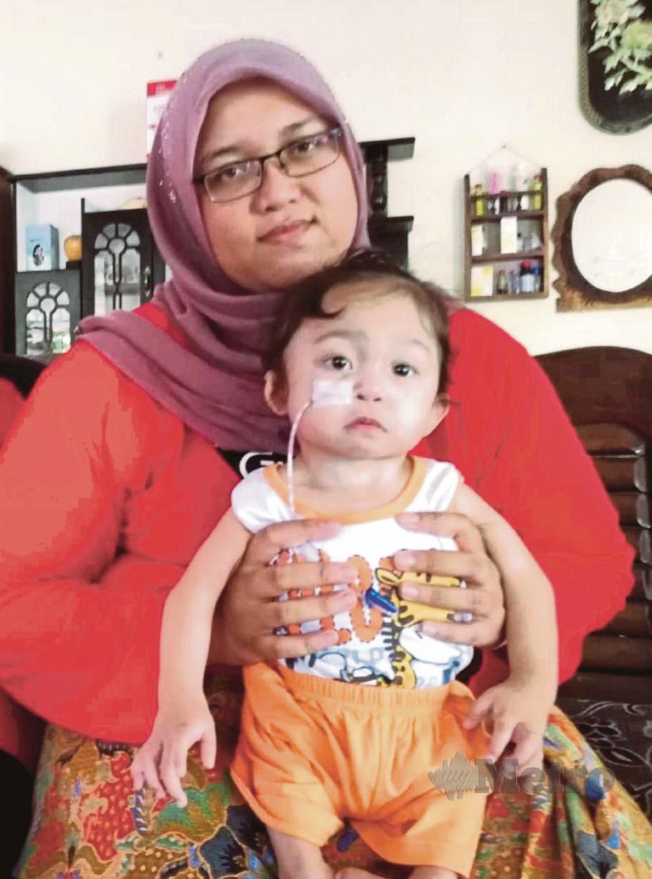 SITI Norzurain Fatima memangku Siti Nurjannah Umaira yang  menghidap tujuh penyakit selepas disyaki  mengalami  sindrom vacterl.