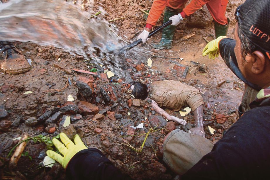 PASUKAN penyelamat mengeluarkan mayat mangsa yang ditemui ditimbus tanah runtuh di Purworejo, semalam.