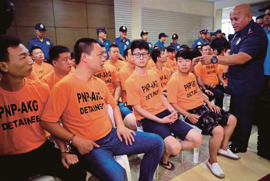 KETUA Polis Filipina, Ronald Dela Rosa bertanyakan sesuatu pada 44 warga asing yang ditangkap kerana menculik wanita Singapura di sebuah resort di Manila, semalam.  - Reuters 
