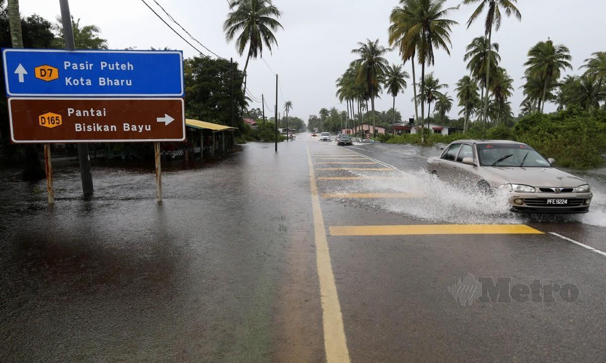 JALAN Kampung Dalam Ru di Pasir Puteh dinaiki air susulan hujan berterusan. FOTO Nik Abdullah Nik Omar.