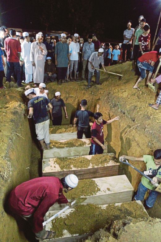  KELUARGA mangsa   tragedi lemas  dikebumi dalam satu liang di tanah perkuburan Pengkalan Arang Kuala Nerus, malam kelmarin.