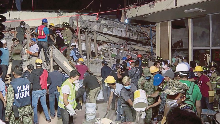 GAMBAR disiarkan pejabat Presiden Enrique Pena Nieto menunjukkan orang ramai dan anggota penyelamat mencari mangsa di dalam runtuhan Sekolah Rendah Enrique Rebsamen di mana mayat sekurang-kurangnya 21 kanak-kanak ditemui. - AFP  