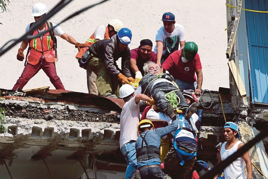 SEORANG mangsa yang terselamat dibawa ke hospital untuk rawatan. - AFP  