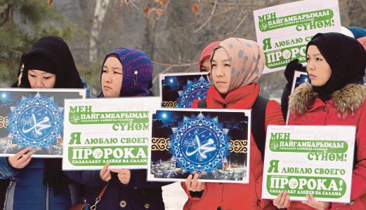 MUSLIMAH Kyrgyzstan memegang poster ‘Saya sayangkan Muhammad’ ketika menunjuk perasaan membantah tindakan biadap majalah satira Perancis Charlie Hebdo di Bishkek, semalam.