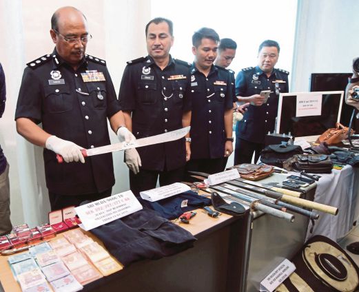  SHAFIEN  (kiri) menunjukkan parang yang digunakan penyamun  pada sidang media di IPK Selangor.