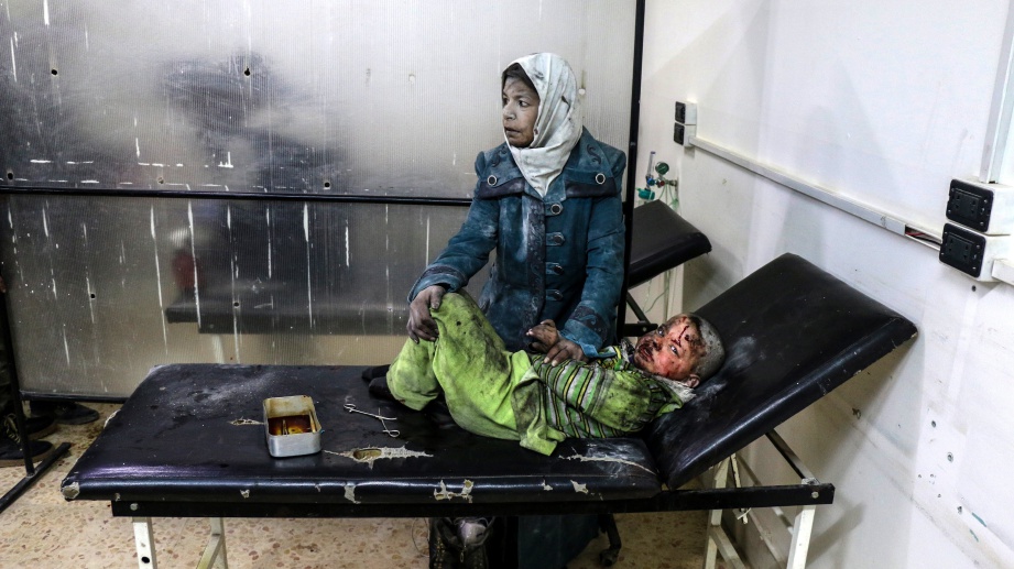 SEORANG wanita yang cedera menjaga anaknya yang terlantar di hospital akibat serangan udara di Barzeh, Damsyik. - EPA