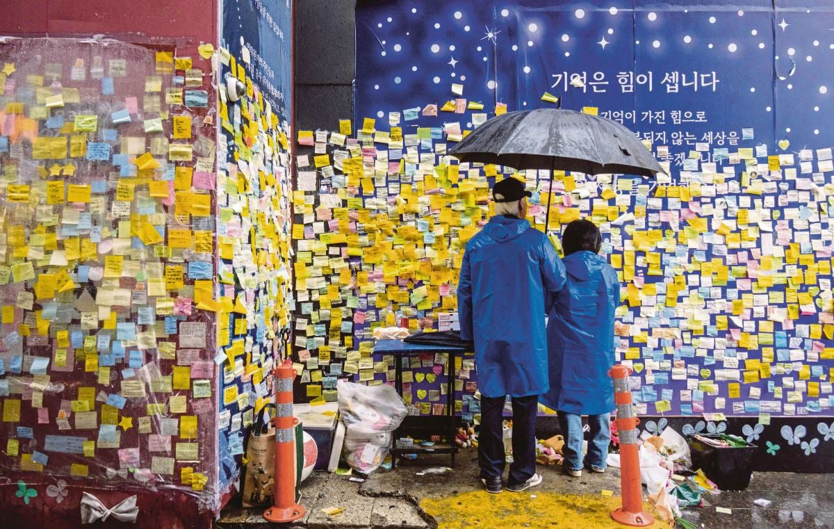 AHLI keluarga mangsa yang terkorban meninggalkan mesej di lorong tempat berlakunya tragedi Itaewon Halloween 2022. FOTO AFP.