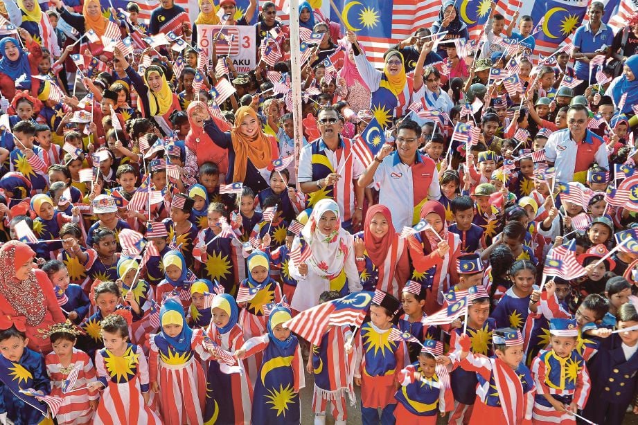 MURID serta ibu bapa mengibarkan Jalur Gemilang sambil menyanyikan lagu patriotik pada Sambutan Hari Kebangsaan Tabika Perpaduan Daerah Klang 2017 di Stadium Kota Raja, Klang. 