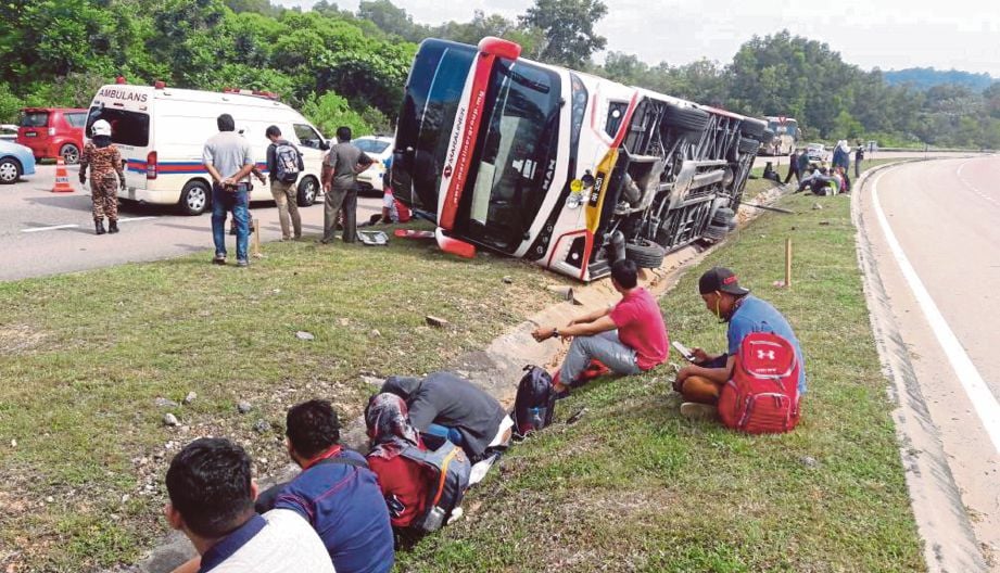 KEADAAN bas ekspres yang terbalik menyebabkan pemandu dan dua penumpang cedera.