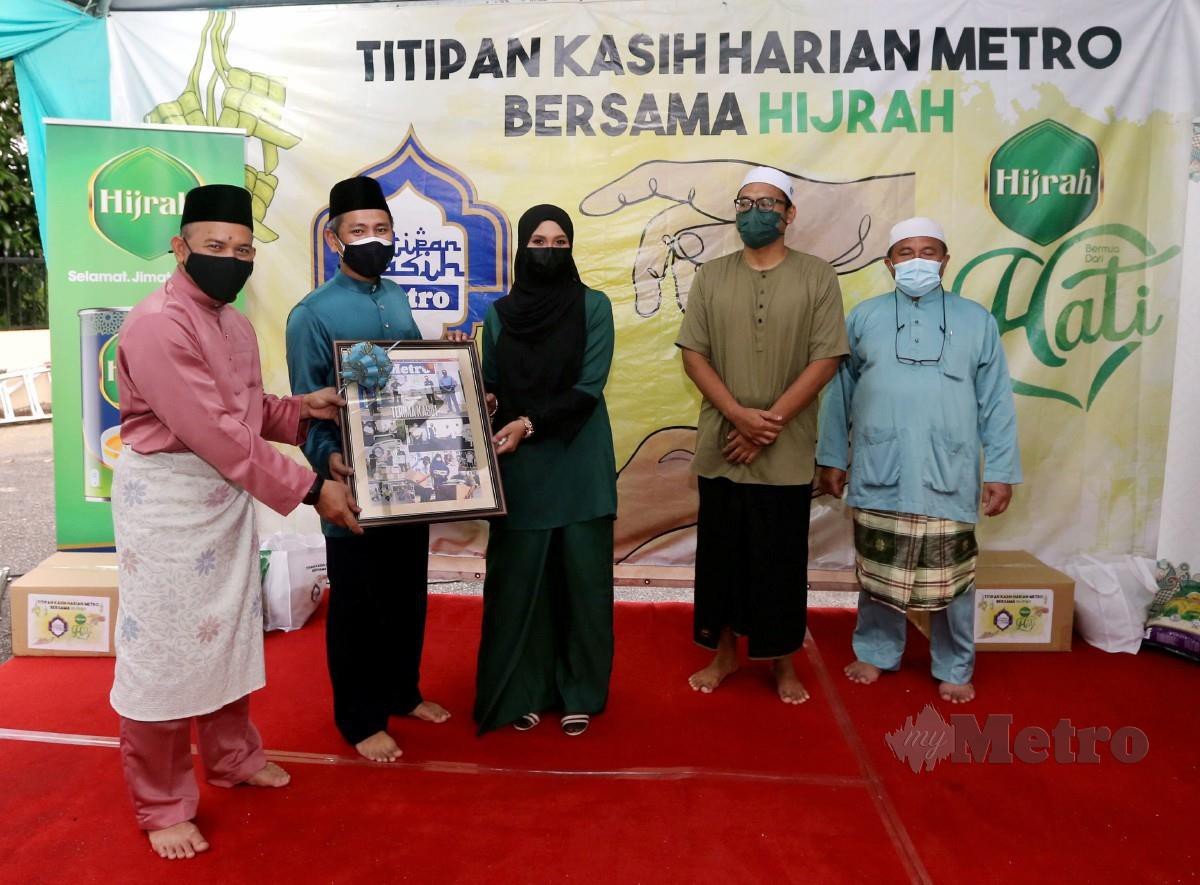 HUSAIN (kiri) bersama Mohd Zurairi (dua dari kiri) menyampaikan cenderamata kepada Siti Nordiana (tengah). FOTO Azhar Ramli