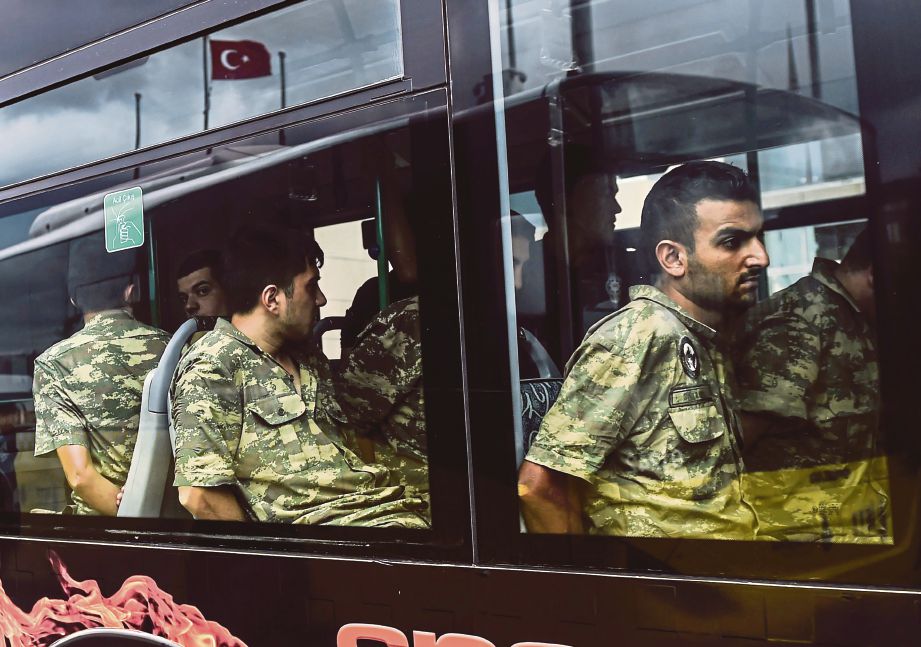 ASKAR Turki yang didakwa mengambil bahagian dalam cubaan rampasan kuasa tiba dengan bas di sebuah mahkamah di Istanbul, semalam.  