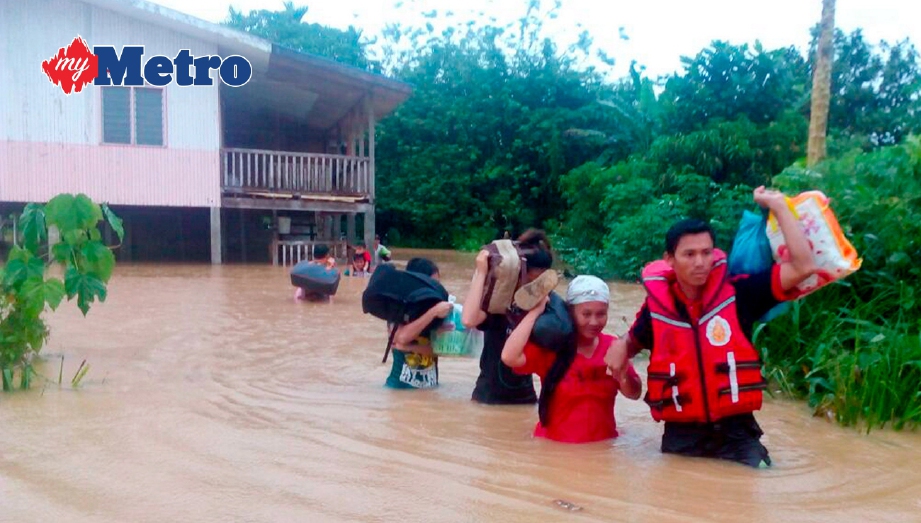 ANGGOTA Bomba dan Penyelamat membantu memindahkan penduduk yang terlibat dalam banjir di Kampung Merion. FOTO ihsan bomba
