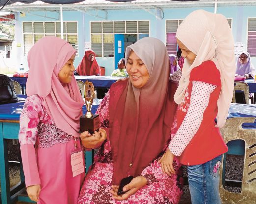 NUR Ain Farzana (kiri) berkongsi kegembiraan bersama ibu dan kakak selepas menjuarai Tilawah Kategori Tadika pada Majlis Perujian Al-Quran Peringkat Daerah Johor Bahru.
