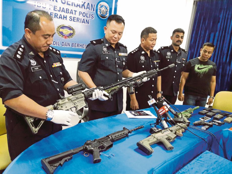 ASWANDY (dua dari kiri) menunjukkan senjata tiruan dan barangan dirampas.