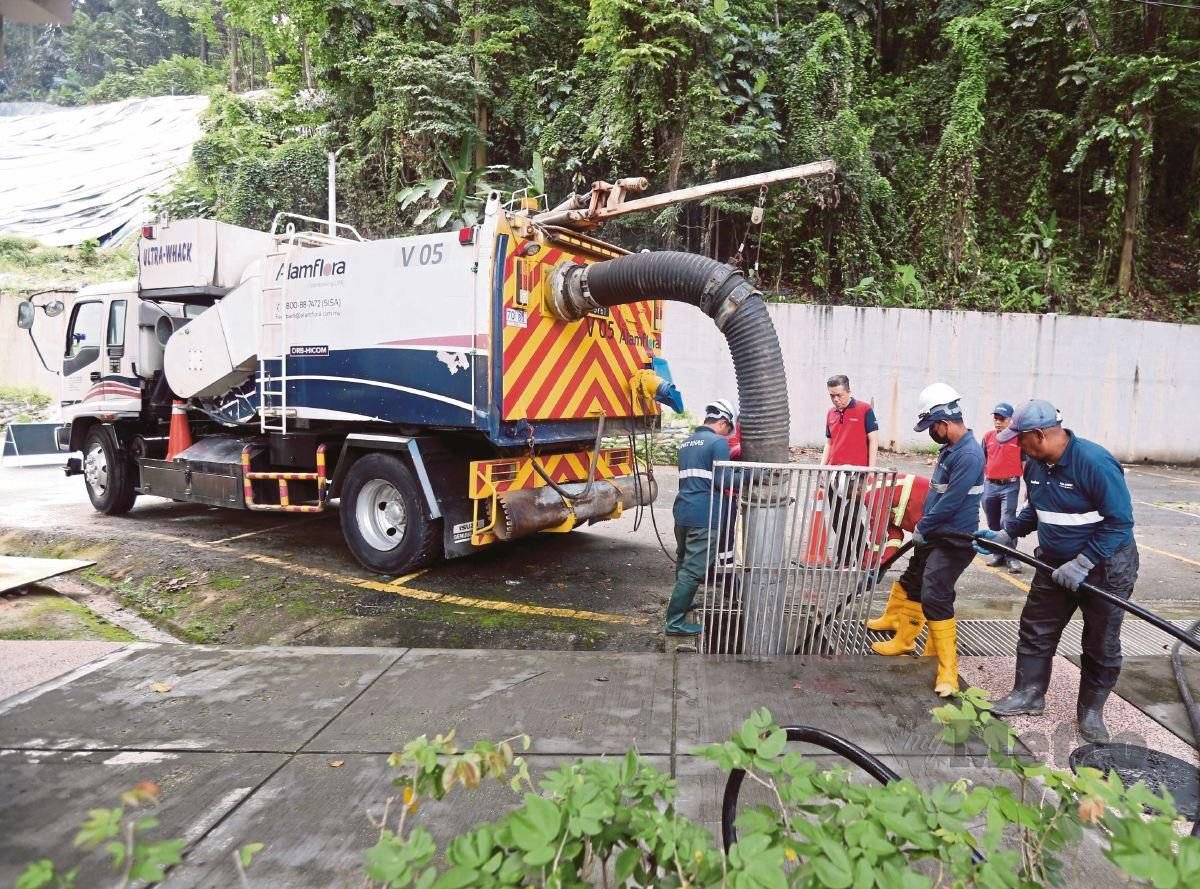 PEKERJA Alam Flora melakukan kerja pembersihan parit di Jalan Ampang (berhampiran Air Terjun Bukit Nanas), iaitu salah satu lokasi panas banjir di Kuala Lumpur.