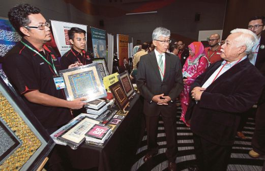 Muhammad Ali  (kanan) bersama Pengerusi Lembaga Pembangunan Pelaburan Malaysia (MIDA) Tan Sri Amirsham A Aziz (dua dari kanan) melawat pameran  pada Konvensyen Aspirasi Usahawan Muslim 2014.