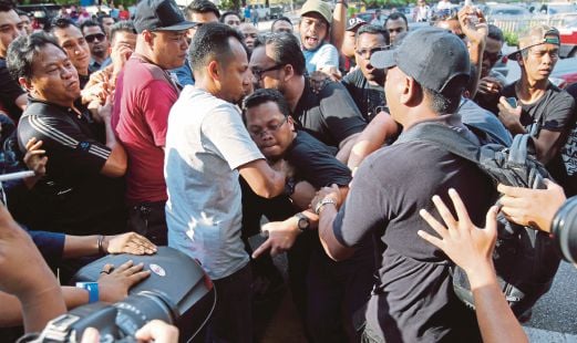 ANGGOTA polis menahan Nik Nazmi (tengah), beliau kemudian dibebaskan selepas pihak berkuasa memberi kata dua, semalam.