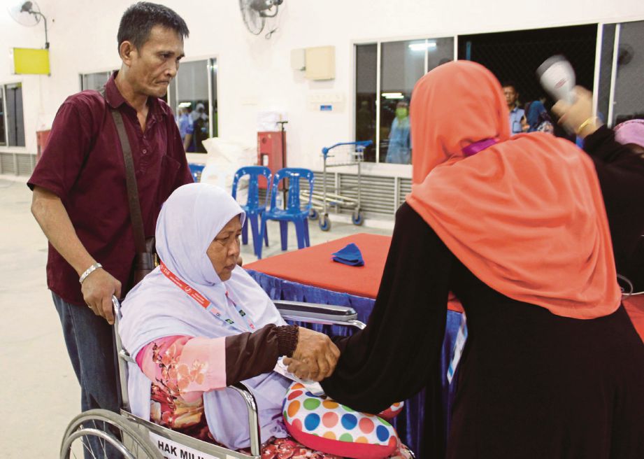 RAHIMAH berurusan di kaunter TH sebelum berlepas menunaikan haji di Lapangan Terbang Antarabangsa Senai.