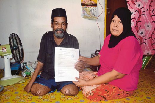 MUHAMAD Sayd bersama Zaharah menunjukkan surat pengesahan hospital mengenai jangkitan kuman dan gangren akibat kencing manis. 