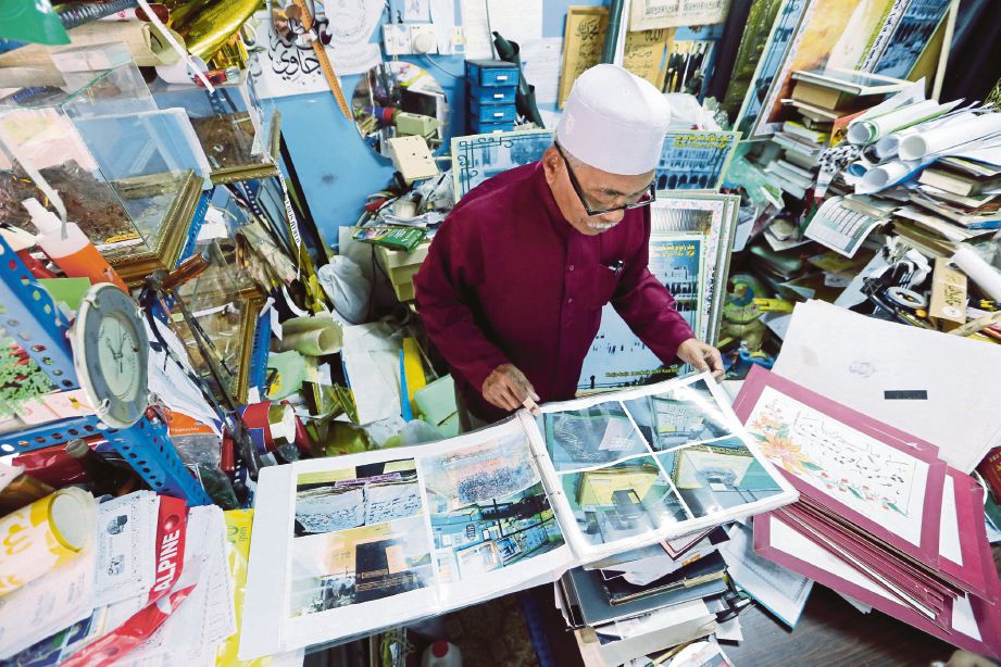  Ahmad melihat gambar lama Makkah yang disimpan di dalam kedainya di bangunan Peruda.