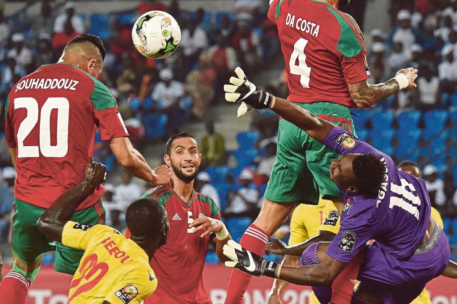 PEMAIN Maghribi Bouhaddouz (kiri) menanduk bola menewaskan penjaga gol Togo, Kossi Agassa.