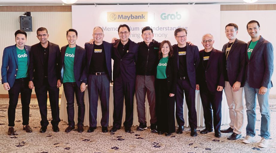 PASUKAN Grab dan Maybank selepas majlis kerjasama strategik servis dompet mudah alih GrabPay. 