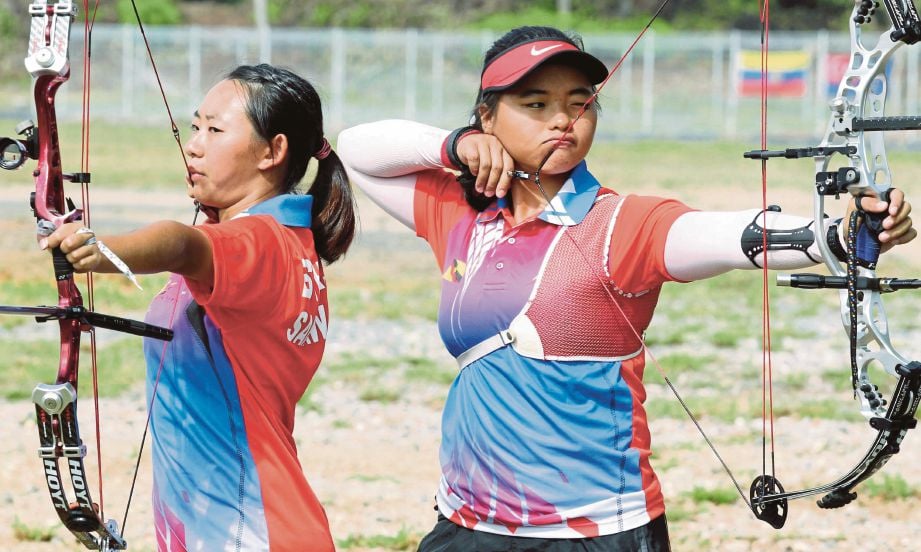 ESTHER Yong (kiri) dan  Yee Ting ketika menjalani latihan di Lapang Sasar Memanah UNIMAS.