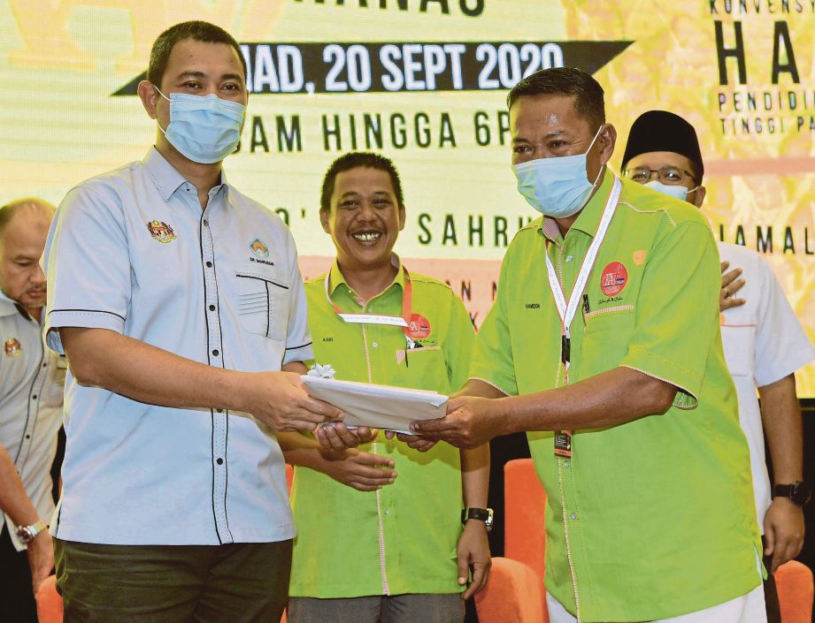 DR Sahruddin (kiri) merangkap Ahli Dewan Undangan Negeri (Adun) Bukit Kepong menyampaikan sijil kursus Taklimat Program dan Pengurusan Teknologi Penanaman Nanas kepada Hamidon Adon. FOTO Bernama