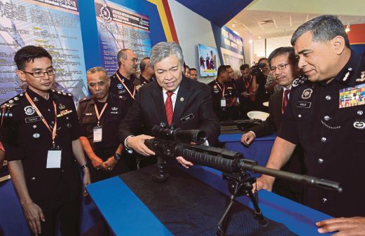 Zahid mencuba senjata yang dipamerkan sambil diperhatikan Khalid di GPEC Asia 2015 ke- 4  di PWTC, Kuala Lumpur. 