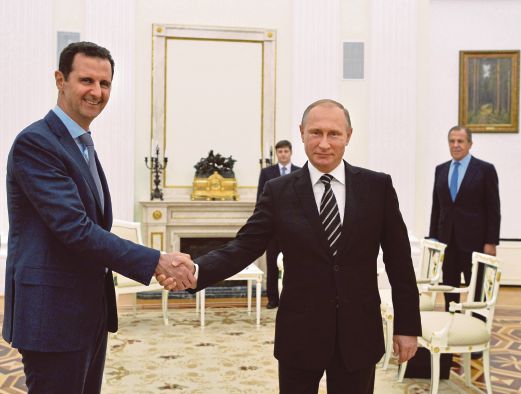 PUTIN (kanan) bersalam dengan Bashar ketika pertemuan di Kremlin, Moscow kelmarin.