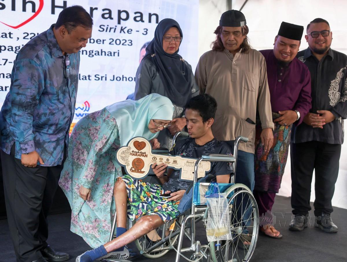 WAN Azizah menyerahkan replika kunci rumah kepada Rosli Hamidon pada penyerahan kunci Program Rumah Kasih Harapan 2023 di Perumahan Awam Seri Johor, Cheras hari ini. FOTO Bernama.