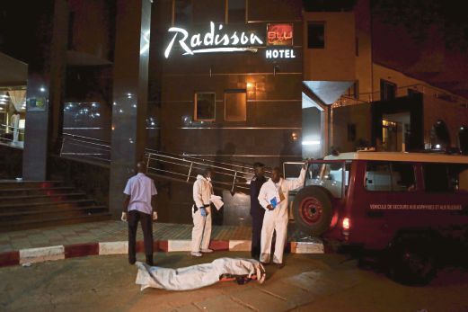 POLIS mengeluarkan mayat mangsa yang terbunuh dalam serangan di Hotel Radisson Blu kelmarin.