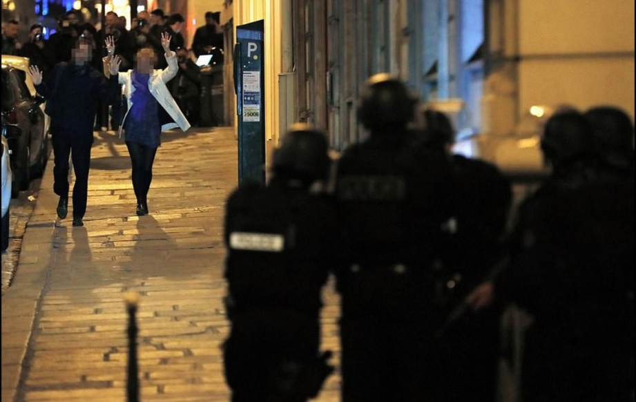 ORANG awam  menunjukkan tangan yang tidak bersenjata ketika dibenarkan keluar dari kawasan kejadian. - Daily Mail 