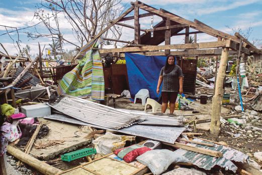 SEORANG wanita memerhatikan rumahnya yang musnah akibat Taufan  Koppu di bandar Casiguran  di wilayah Auroran, timur laut Manila.   