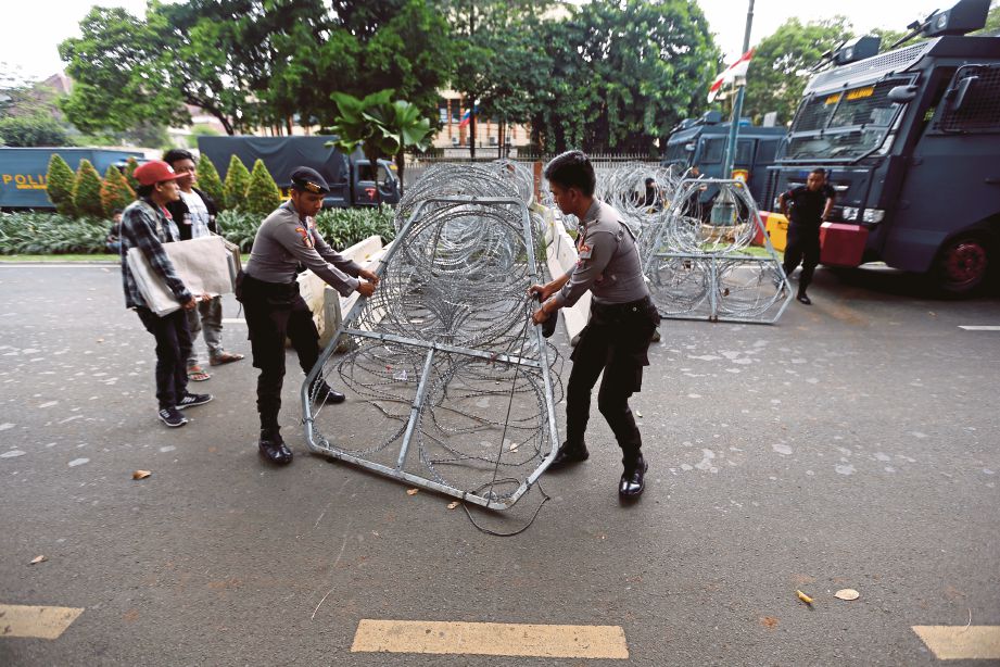 ANGGOTA polis memasang halangan di luar pejabat Suruhanjaya Pilihan Raya di Jakarta, semalam selepas pengumuman keputusan pilihan raya presiden. FOTO Reuters 