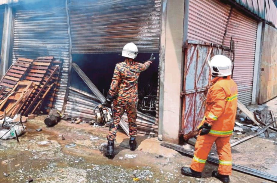    Anggota bomba memadamkan kebakaran gudang perabot dan bengkel kereta di Jalan Puchong Batu 6 1/2, semalam.