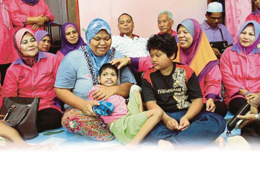  Norlina (dua dari kiri ) memangku Nurfarhana   ketika  menerima kunjungan sukarelawan Homehelp JKM Kuala Selangor. 