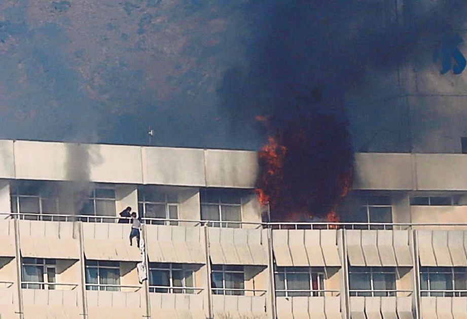 BEBERAPA tetamu dilihat cuba menyelamatkan diri dari bilik hotel yang terbakar dengan turun menggunakan cadar. - Reuters