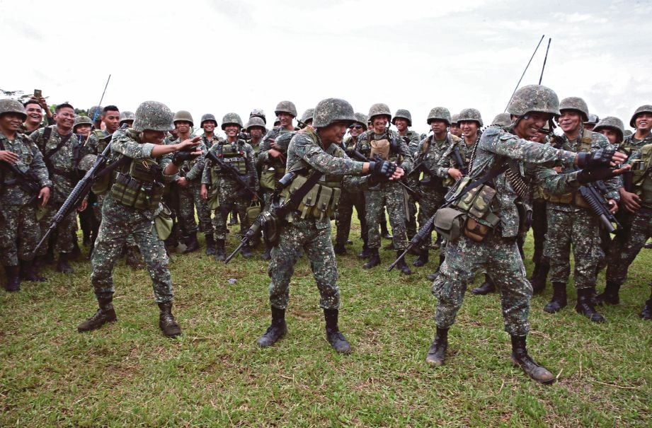 ANGGOTA Batalion Marin Pasukan Pendaratan membuat tarian ‘Baby Shark’ selepas upacara pengunduran di Marawi semalam. - Reuters