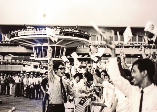 MANTAN Pengurus Pemasaran Sukan, Leonard Wee  (kiri) mengetuai sorakan penyokong kepada pasukan bola sepak kebangsaan sekembalinya dari 