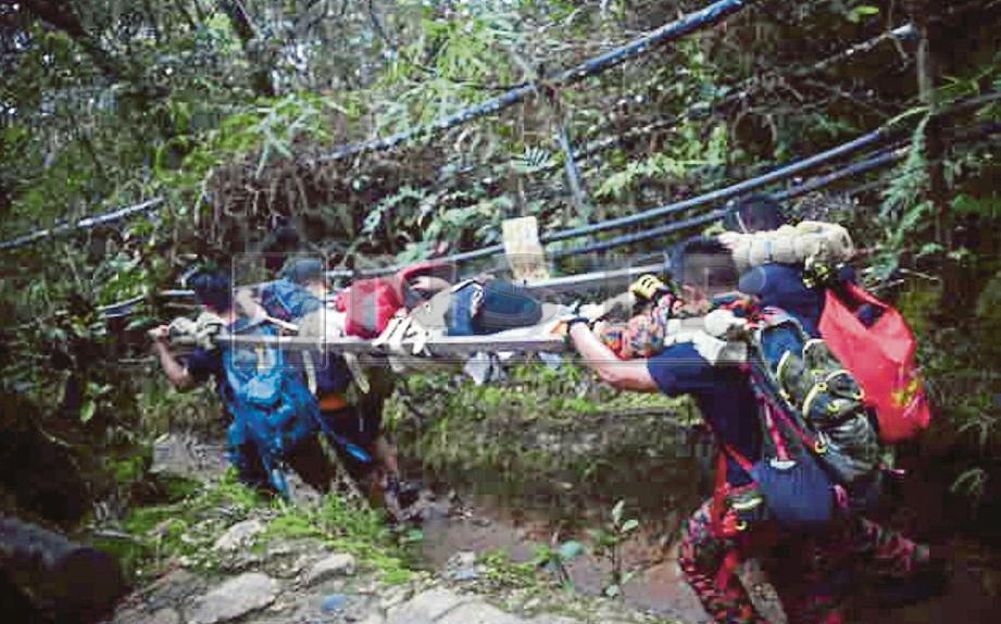 ANGGOTA PBB MOSAR bersama petugas di Gunung Kinabalu membawa turun remaja perempuan berusia 15 tahun yang cedera ketika mendaki Gunung Kinabalu, baru-baru ini.